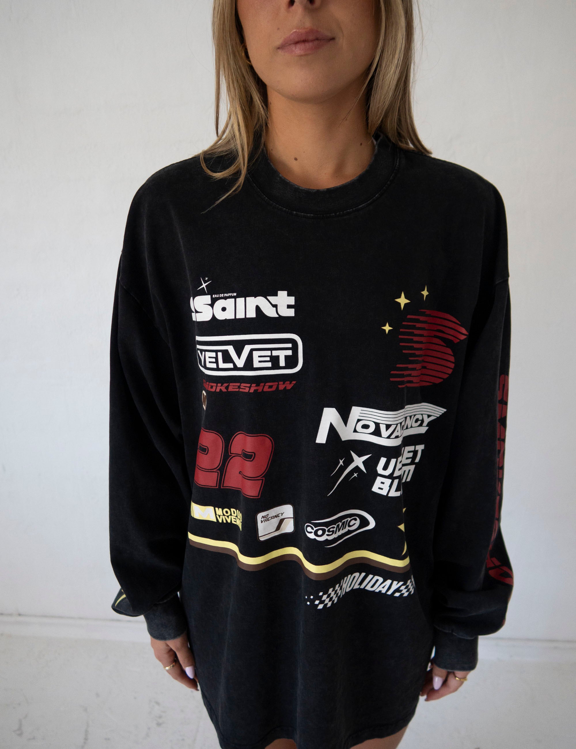 lose up of SSAINT Signature Moto Tee graphic print and fragrance artwork in Black Acid Wash