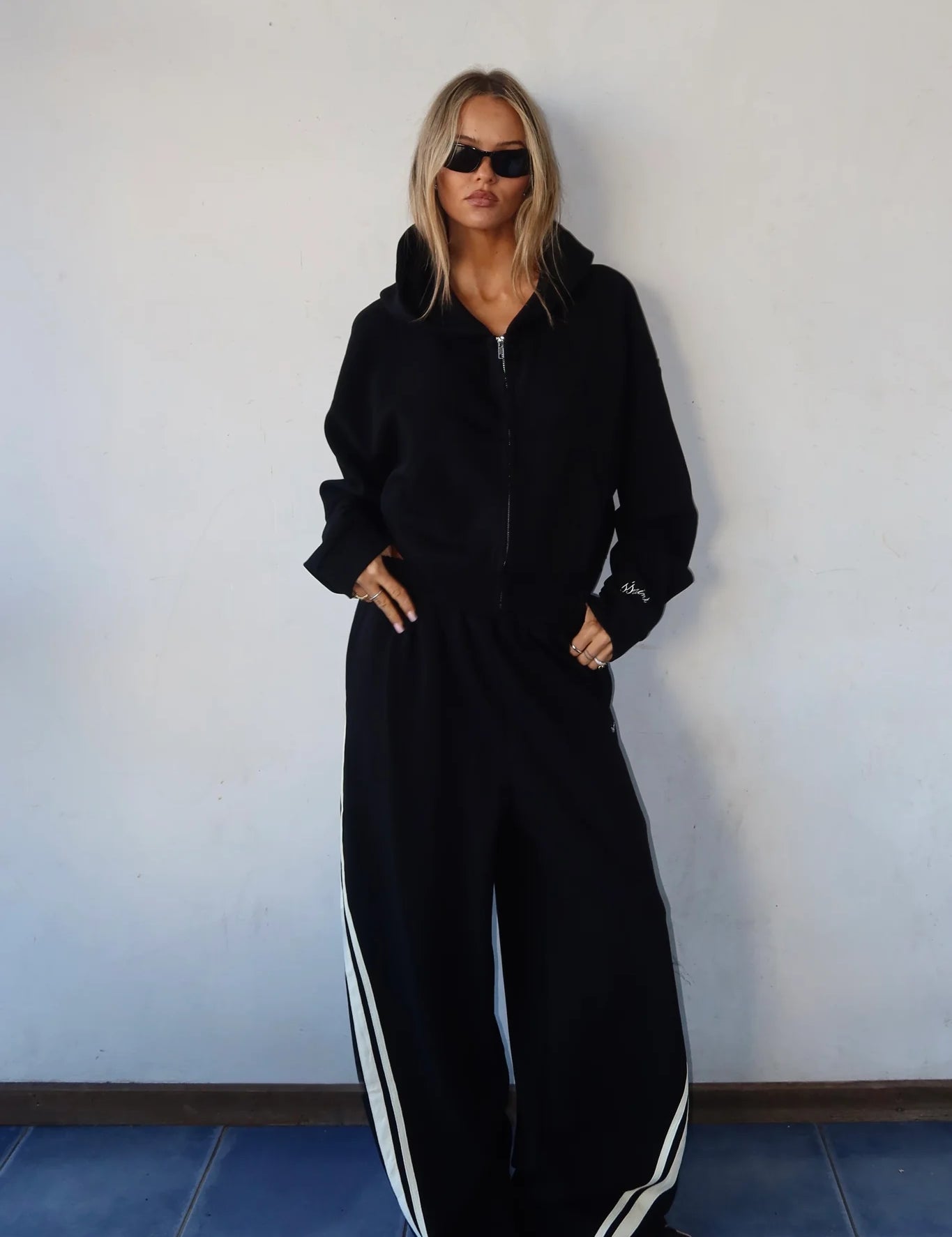 MODEL WAERING SSAINT BLACK SET CROPPED HOODIE AND BARREL PANTS
