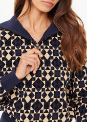 Person wearing a navy and beige patterned jacket with a close-up of the collar.