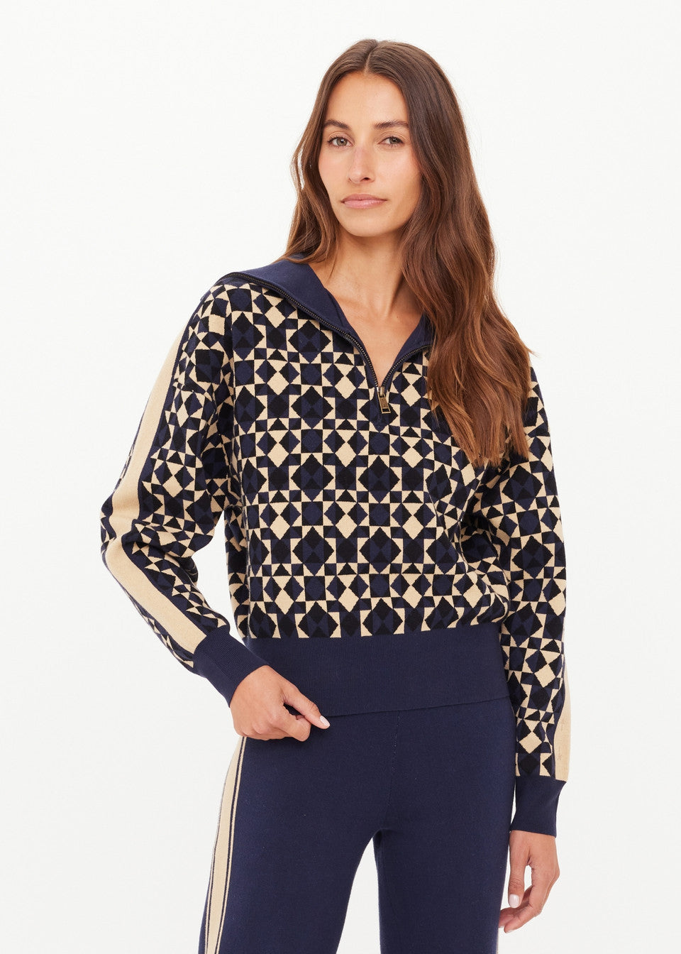 Woman wearing a patterned top with navy accents on a white background