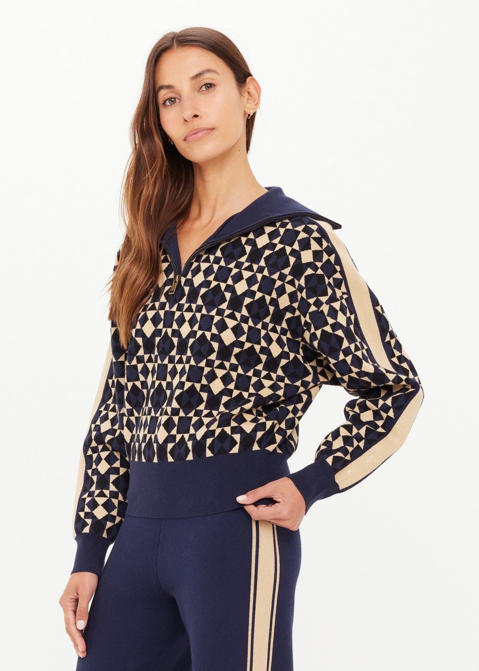 Woman wearing a patterned sweater with navy and beige accents on a white background