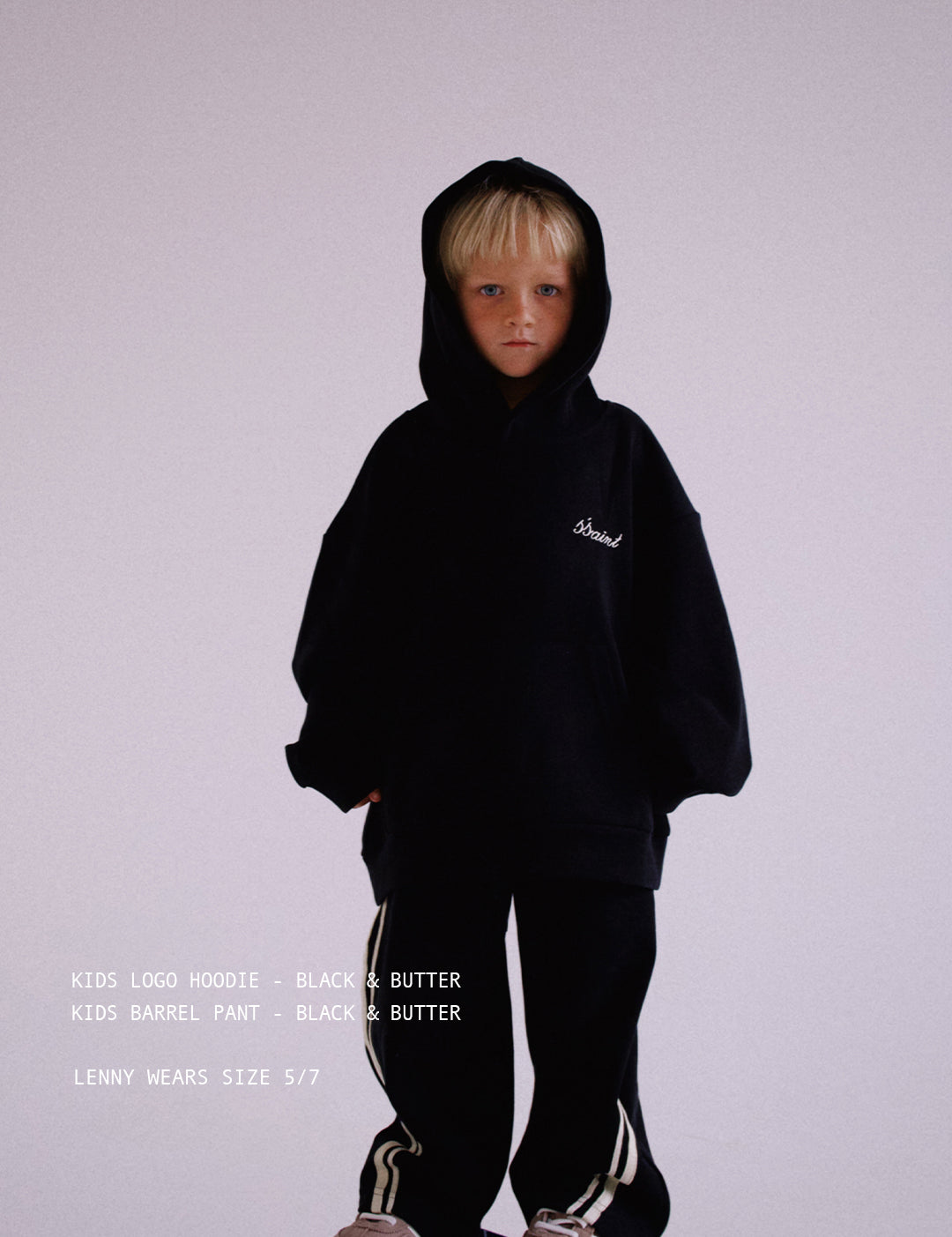 Child wearing ŚSAINT logo hoodie in black and butter colourway