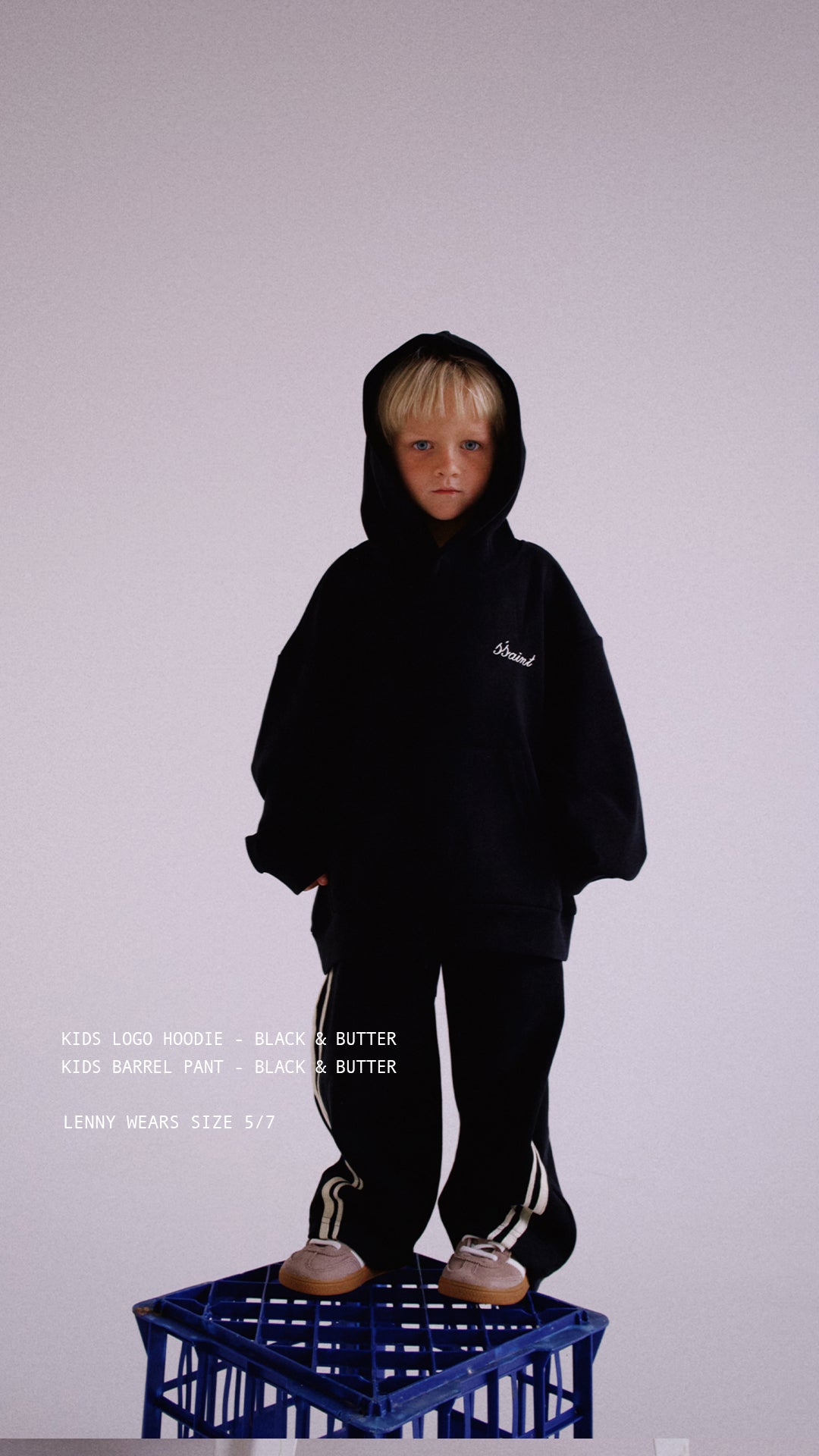 Child wearing ŚSAINT logo hoodie in black and butter colourway