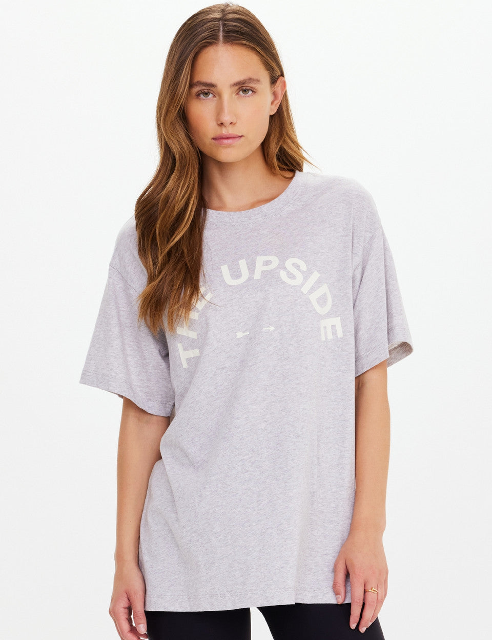 Woman wearing a gray t-shirt with text on a white background