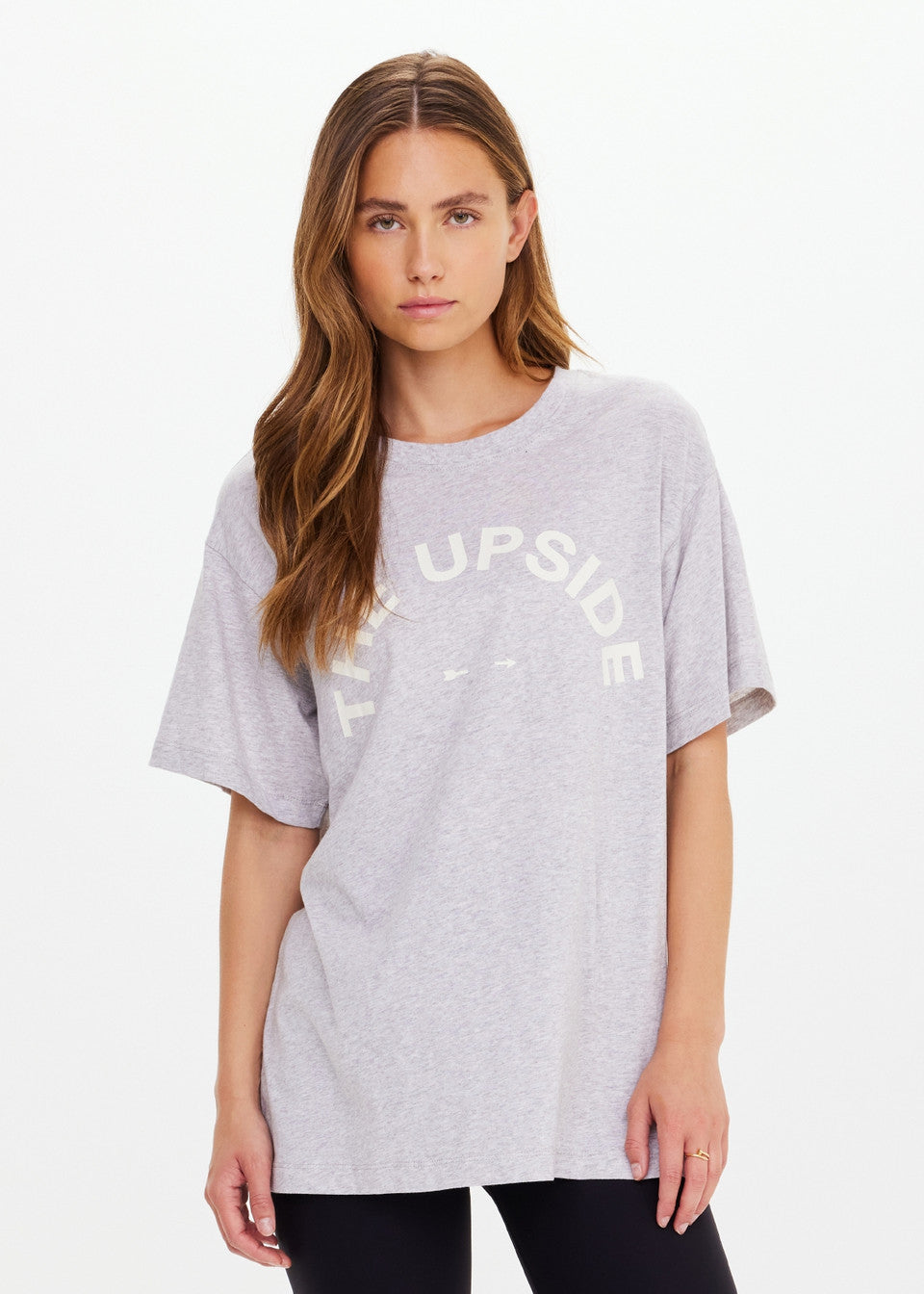 Woman wearing a gray t-shirt with text on a white background