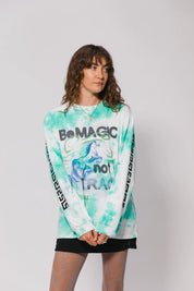 Person wearing a tie-dye long-sleeve shirt with text on a plain background