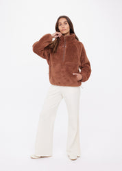 Woman wearing The Upside Harlow Fleece Pullover in Walnut brown — relaxed sherpa layer styled for everyday wear