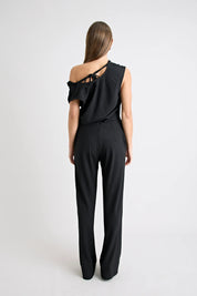 Black one-shoulder jumpsuit worn by a model on a white background