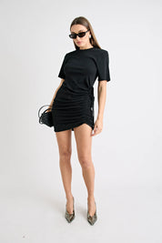 Woman wearing a black outfit with sunglasses on a white background