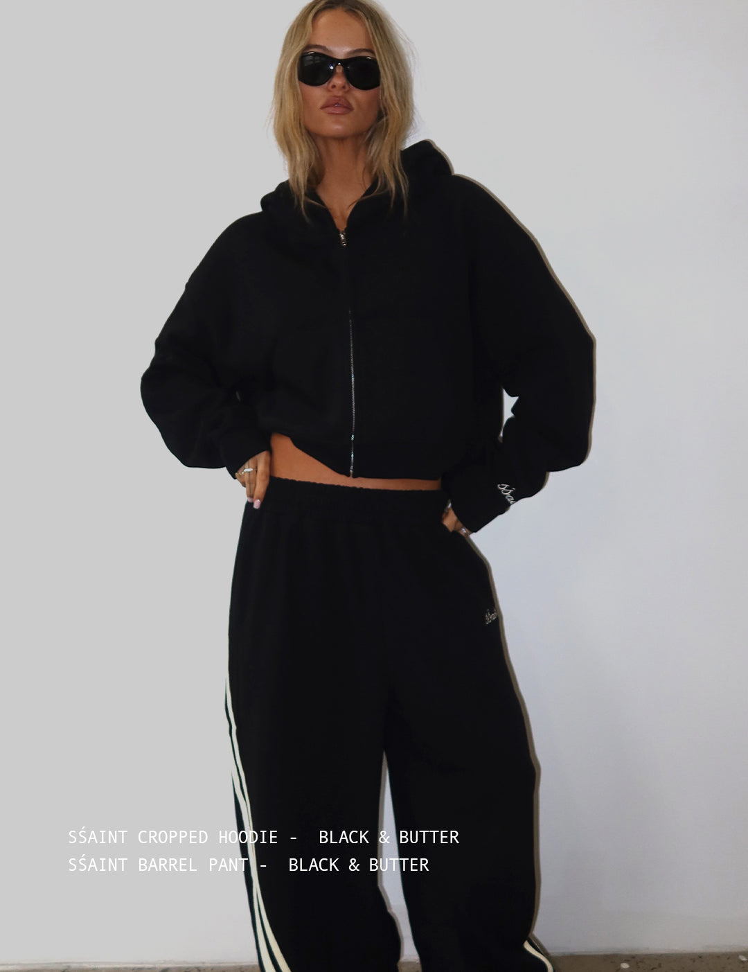 Woman wearing ŚSAINT black and butter cropped zip hoodie