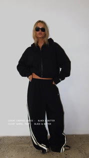 Woman wearing ŚSAINT black and butter cropped zip hoodie
