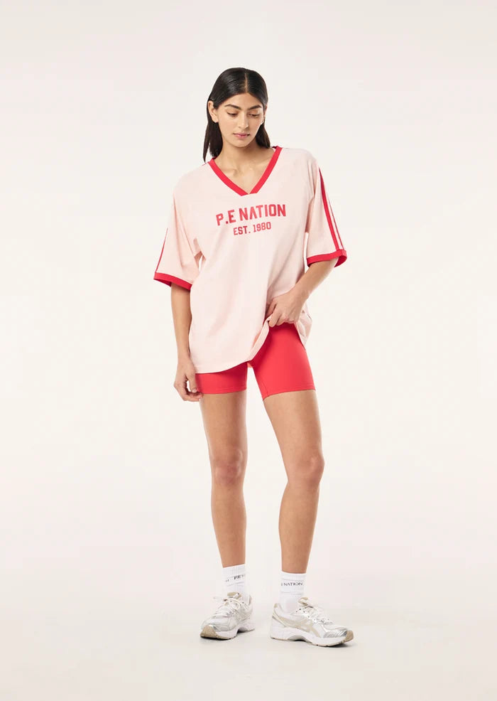 model shot wit matching shorts P.E Nation Spinout Baseball Tee in Soft Pink - oversized organic cotton jersey with contrast binding