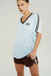 “Side view of Summi Summi V-Neck Jersey Tee in Icel Blue showing V-neckline and subtle shoulder stripe detail.”