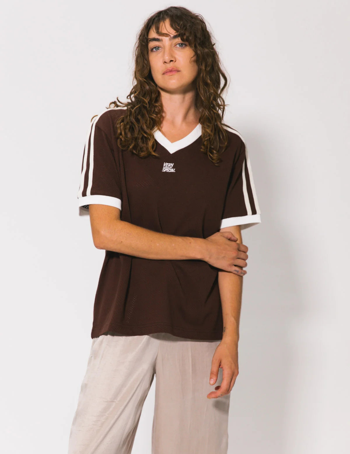 Person wearing a brown sports jersey with white accents on a plain background