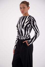 Model wearing Jasmine Alexa Soho Zebra Top with tailored trousers, size small