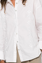 White shirt with intricate embroidery on a plain background