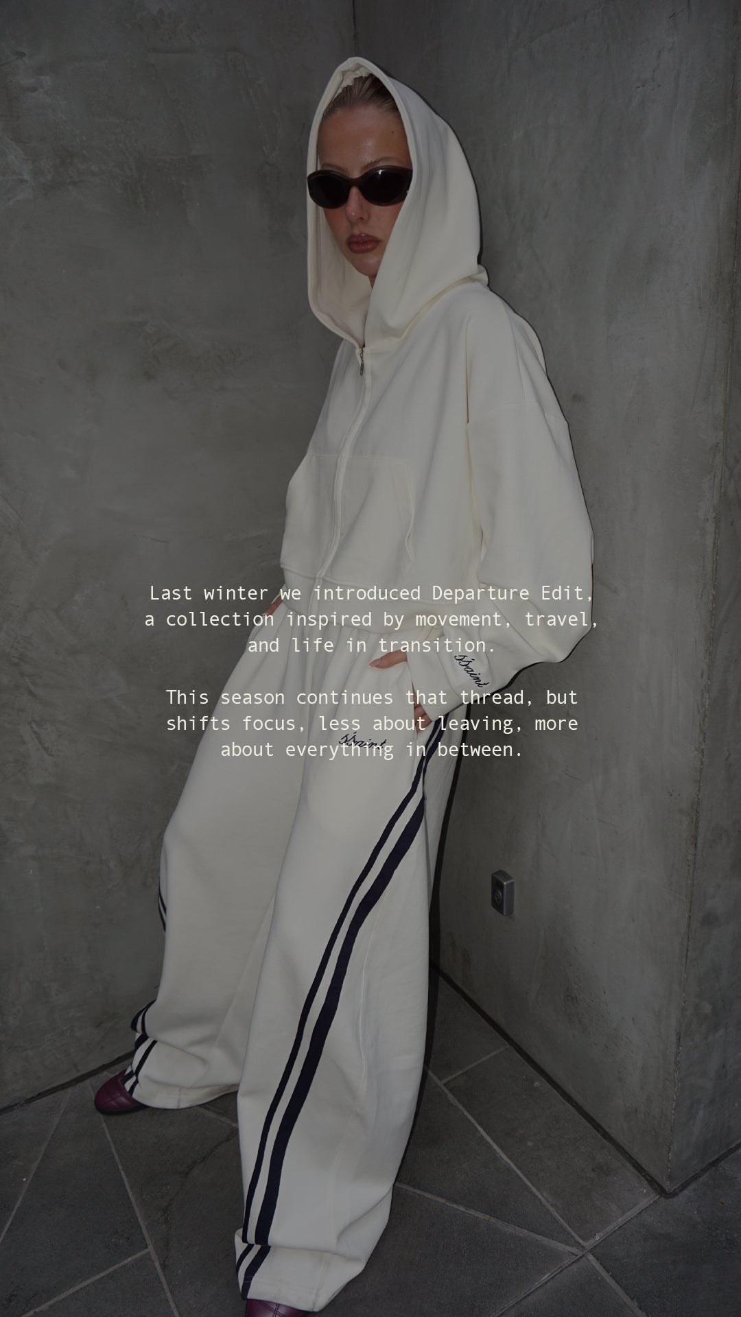 Woman wearing ŚSAINT butter and navy cropped zip hoodie