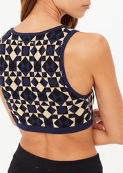 Navy and beige geometric patterned sports bra on a model against a white background