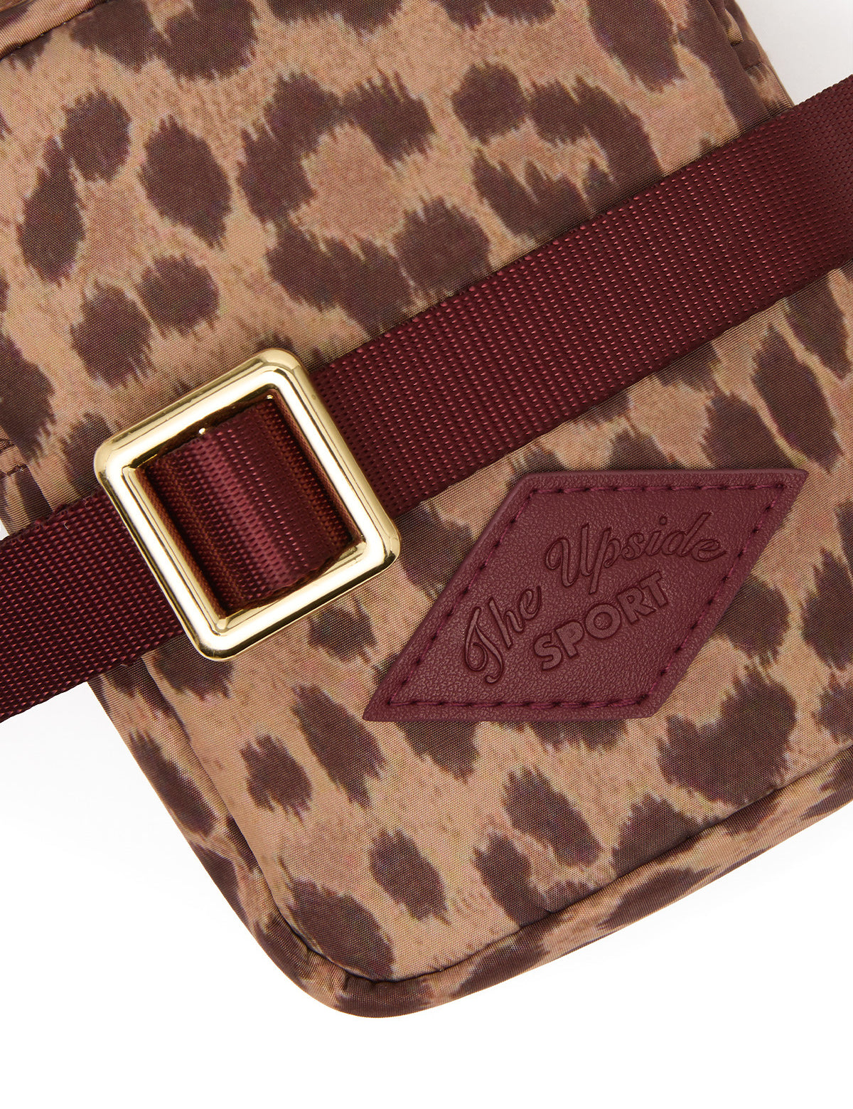 The Upside Javan Lilo Crossbody Bag in leopard print with burgundy strap and gold hardware