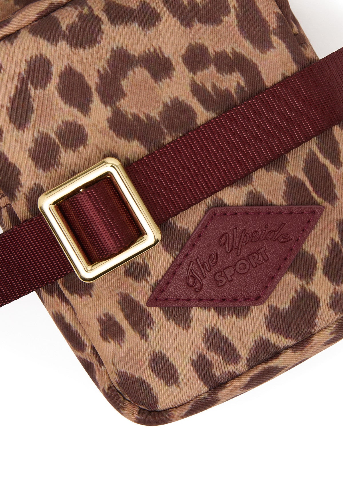 The Upside Javan Lilo Crossbody Bag in leopard print with burgundy strap and gold hardware