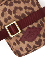 The Upside Javan Lilo Crossbody Bag in leopard print with burgundy strap and gold hardware