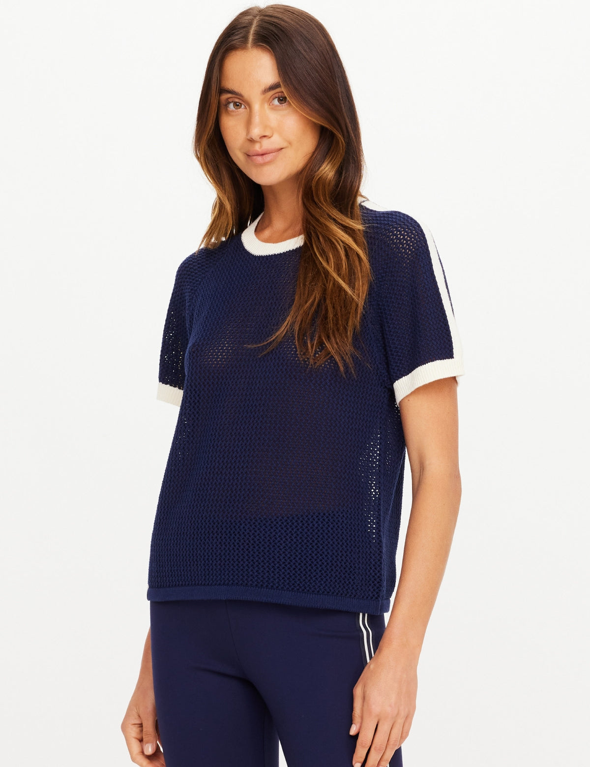 The Upside Fenway Jordan Knit Tee in navy with cream stripe sleeve detail on model with matching flare pants