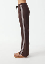 side model wearing The Upside Petra flare pant in chocolate with pink stripe detail – Wild West Sisters