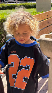 Close-up of orange 22 number graphic and blue ribbed trim on Kids Twenty Two Tee, Wild West Sisters