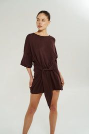 Close-up of adjustable wrap tie on Summi Summi Knit Tie Front Dress in Chocolat, worn tied at the waist.