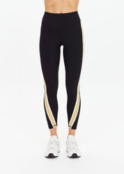 The Upside Arcadia 25in High Midi Pant in black with contrast tan side panels, high-rise sculpted fit.”